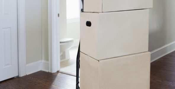 Moving house, relocation, cardboard boxes piled up in a house